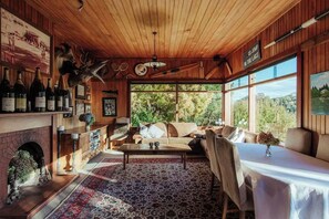 Una habitación acogedora con chimenea, un sofá, una mesa de centro y vistas al exterior.
