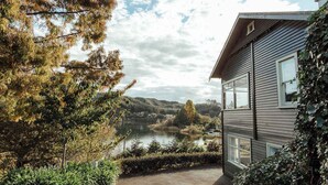 Una casa con vista a un lago y colinas al fondo.