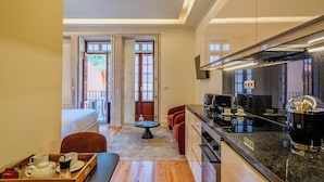 A compact hotel room with a kitchenette, a dining area, and a bed. - YOUROPO - Collection (Porto)