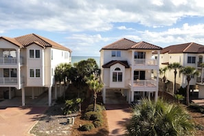 Un hôtel situé en bord de mer, composé de bâtiments à plusieurs étages, doté de balcons et offrant une vue dégagée sur l’océan.