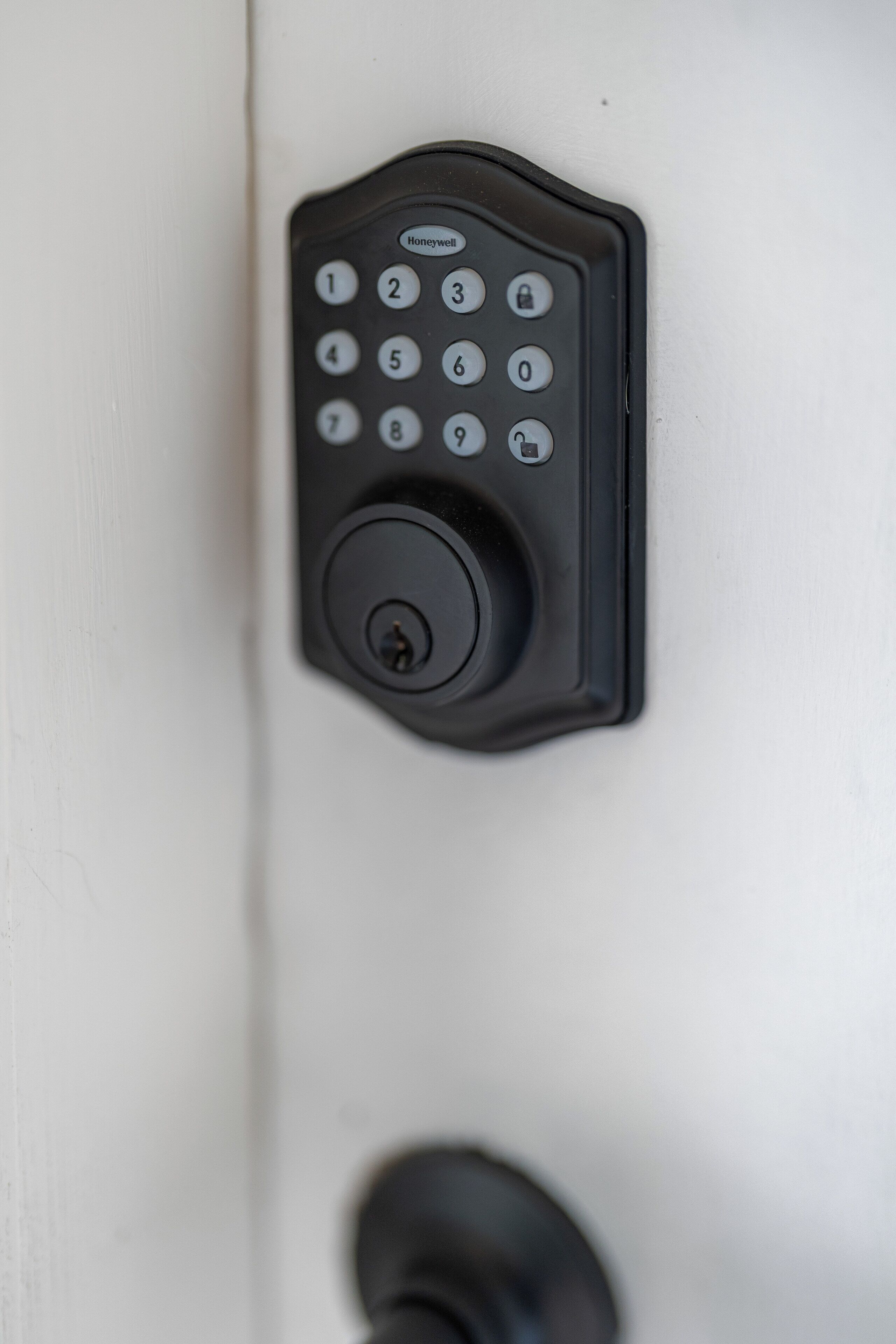 A black electronic keypad on a white door, likely for a hotel room entry.