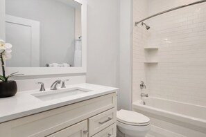 Ein modernes Badezimmer mit Waschbecken, Spiegel und Toilette.