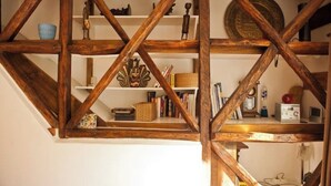 Techo de madera con vigas a la vista y estantes con diversos objetos.