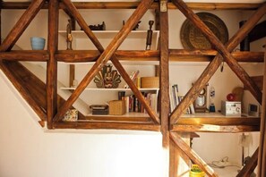 Techo de madera con vigas a la vista y estantes con diversos objetos.