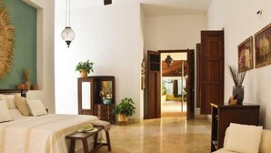 A spacious room with a bed, a desk, and a chair. There is a wooden cabinet and a plant on the floor. - Luxurious and Private Hacienda near Merida (Fraccionamiento Chuntuak, Molas)