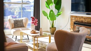 A living room with a sofa, a coffee table, a potted plant, and a flat-screen TV. - StayAU Private Two-Storey 6 Beds House Wendouree (Wendouree)