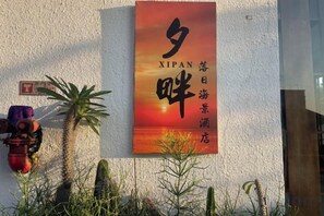 Una pared con un cartel que muestra caracteres chinos y la palabra 'XIPAN' en inglés.