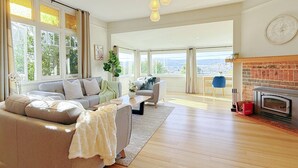 A spacious living room with a sofa set, a coffee table, and a fireplace.