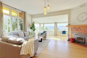 A spacious living room with a sofa set, a coffee table, and a fireplace. - StayAU 2BR Home w/ Stunning Views in Tasmania (Trevallyn)