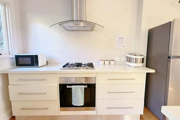 A modern kitchen with a microwave, stove, and refrigerator.