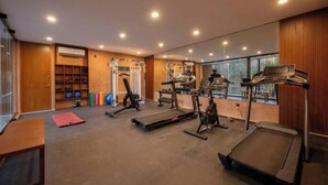 Un gimnasio moderno con cintas de correr, máquinas de pesas y diversos equipos de ejercicio.