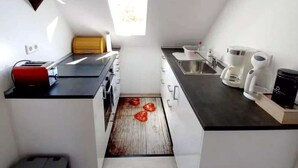 Cafetera o tetera, frigorífico, horno y placa de cocina