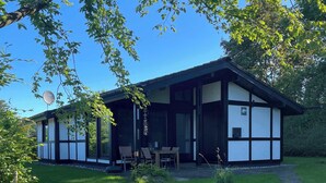 A traditional Japanese-style house with a covered porch, a small garden, and a pathway leading to the entrance. - Sauerländer Henne-Lütt (Meschede)