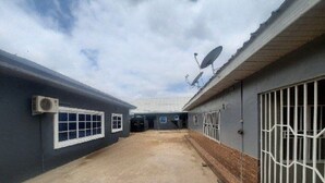 A corridor with a concrete floor, a satellite dish, and a barred gate. - StayComidad
Your comfort, Our Priority. (Tamale)