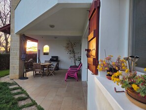 An outdoor patio with a dining table, chairs, and a grill. - Hasparren, family apartment 114m², garden and view, sleeps 6. (Hasparren)