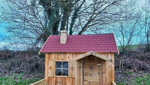 A small wooden cabin with a red roof, a window, and a door. - Apfelhaus am Hennesee (Meschede)
