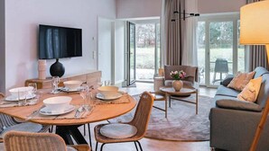Een moderne woonkamer met een eethoek, een bank en een televisie.
