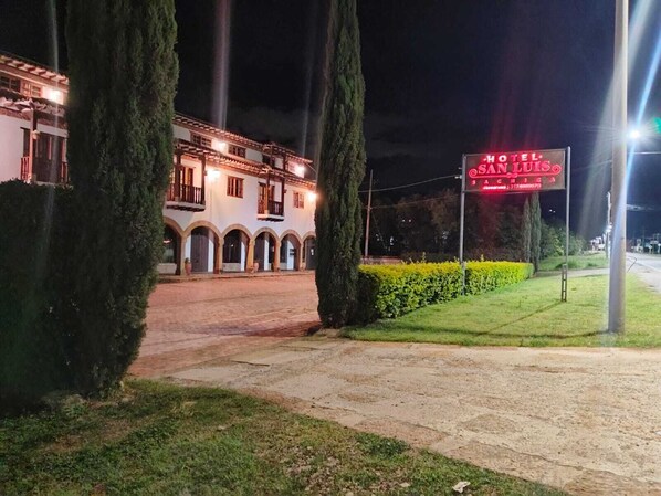 A hotel with a traditional architectural style, featuring a central courtyard and arched walkways.