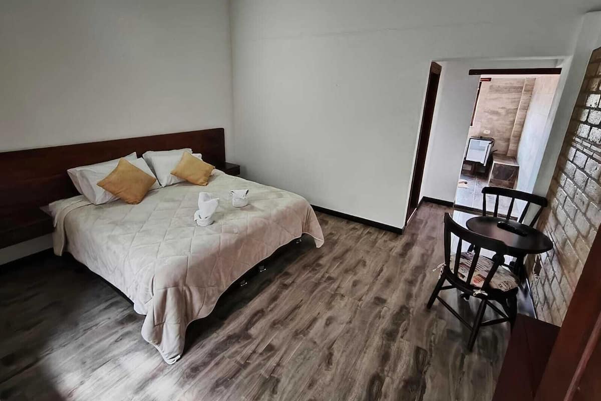Une chambre d’hôtel avec un lit, une chaise et une petite table.