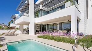 Un hôtel moderne doté d’une piscine, d’un espace extérieur aménagé et d’un jardin bien entretenu.
