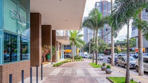 A modern building with a glass facade and a brick base, featuring a sign that reads "DNA Smart Home." - Incredible Stay With Pool and gym in Setor Bueno - Dnag (Goiânia)