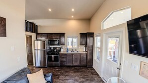 Une cuisine moderne avec des meubles en bois foncé, des appareils électroménagers en acier inoxydable et une grande fenêtre.
