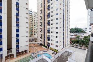 A high-rise residential building with multiple balconies, a rooftop pool, and a view of the surrounding cityscape. - Apartment Next to Flamboyant Shopping Mall - ESS (Goiânia)