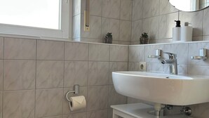 Ett badrum med toalett, handfat och spegel.