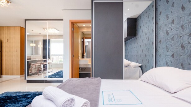 Habitación de hotel con cama, baño y vista a un comedor.