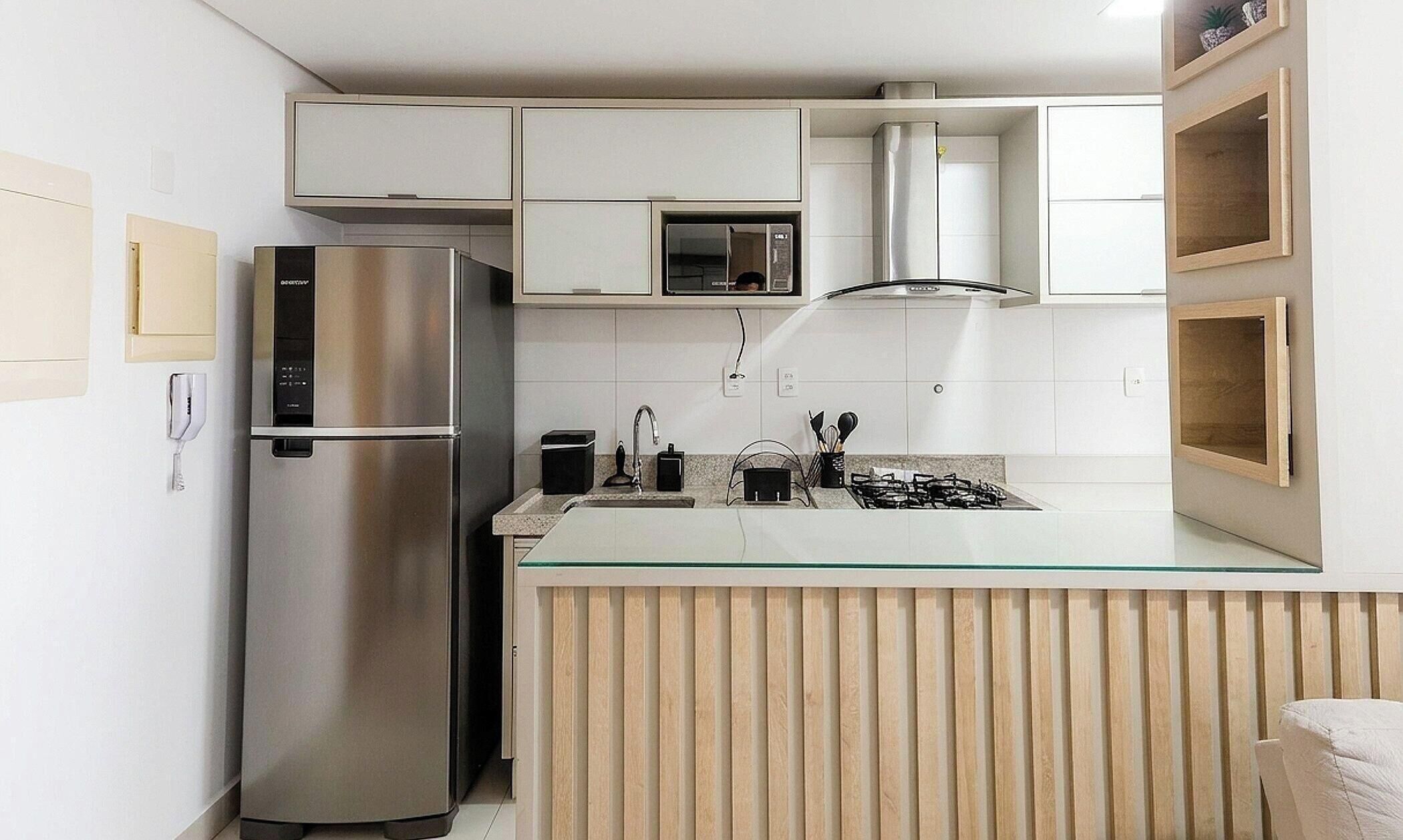 Eine moderne Küche mit einem Edelstahl-Kühlschrank, einer Mikrowelle und einem Gasherd.