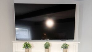 Ein weißer Kamin mit einem flachbildfernseher darüber.