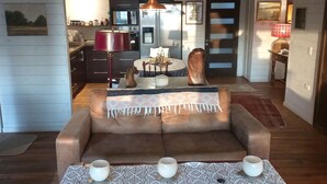 Ein gemütliches Wohnzimmer mit einer Couch, einem Couchtisch und einem Essbereich mit Tisch und Stühlen.