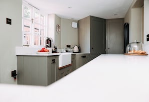 A modern kitchen with a large island, a window, and a door.