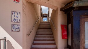A staircase leading to a building entrance with a fire extinguisher and numbered signs on the wall. - GuestHost - Elegant Beachfront Wi-Fi & Parking (Golfo Aranci)