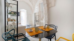 Un comedor con una vitrina de vidrio, una mesa con sillas y una escalera al fondo.