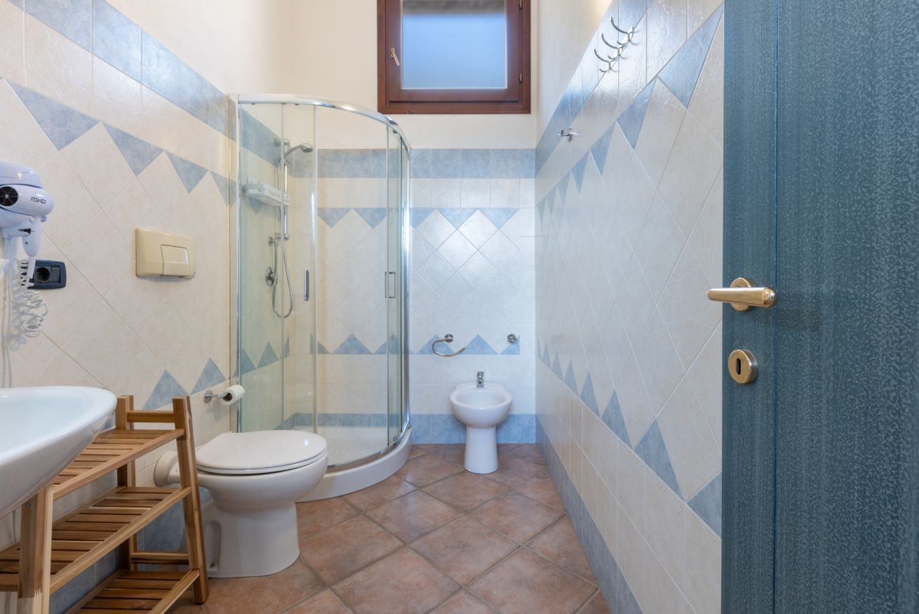 Une salle de bain avec une douche à parois de verre, des toilettes, un bidet et un lavabo.