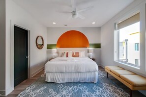 A modern bedroom with a large bed, a ceiling fan, and a view of the outside. - East Nash Lux - 13 Beds City Views (Nashville)
