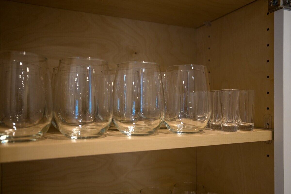 A shelf with various clear glassware items.