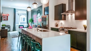 A modern kitchen with a central island, stainless steel appliances, and pendant lighting.