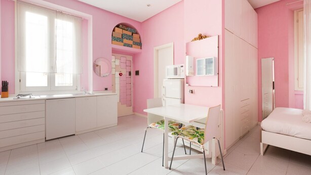 A pink-themed room with a white desk, chair, and bed. - GuestHost - Island Cosy Pink Studio Apt (Milano)