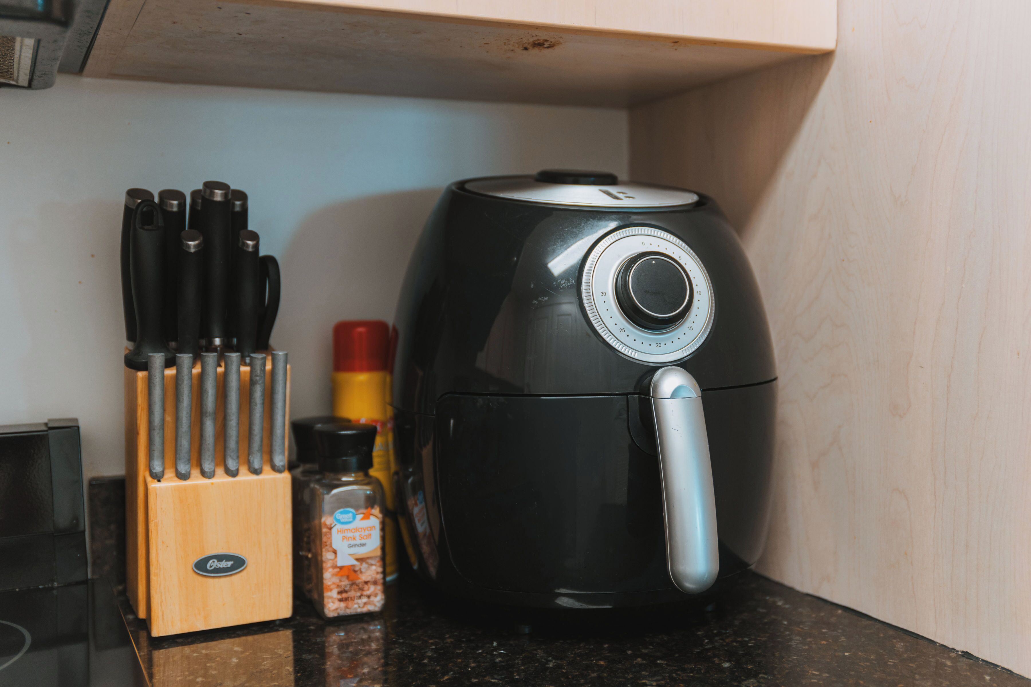A kitchen counter with a coffee maker, a spice rack, and a knife block.