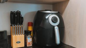 A kitchen counter with a coffee maker, a spice rack, and a knife block.