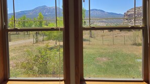 A room with large windows offering a view of a mountainous landscape.