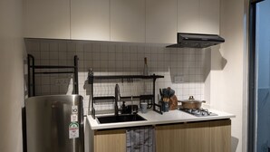 A modern kitchen with a stainless steel refrigerator, a built-in oven, and a gas stove. - Studio apartment in Nairobi, close to JKIA airport and SGR, WiFi, pool & gym (Nairobi)