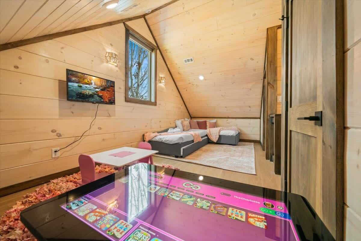 Un dormitorio acogedor con cama, televisor y una mesa con pantalla digital.
