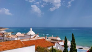 A coastal town with white buildings, a dome structure, and a view of the sea. - Studio apartment with stunning sea views in the heart of the city (Albufeira)