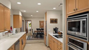 Une cuisine moderne avec des meubles en bois, des appareils en acier inoxydable et un îlot central.