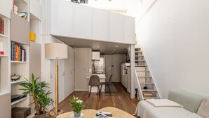 A compact living space with a kitchenette, a dining area, and a staircase. - Bright & Chic Duplex with A/C – Heart of Paris 9th (Paris)