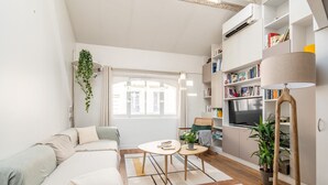 A modern living room with a sofa, coffee table, and bookshelf. - Bright & Chic Duplex with A/C – Heart of Paris 9th (Paris)