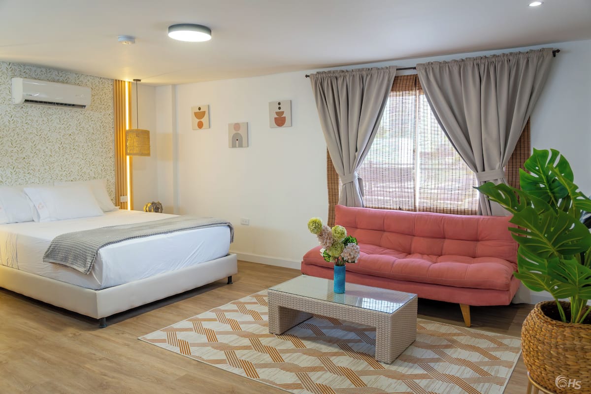 A modern bedroom with a bed, a sofa, and a coffee table.